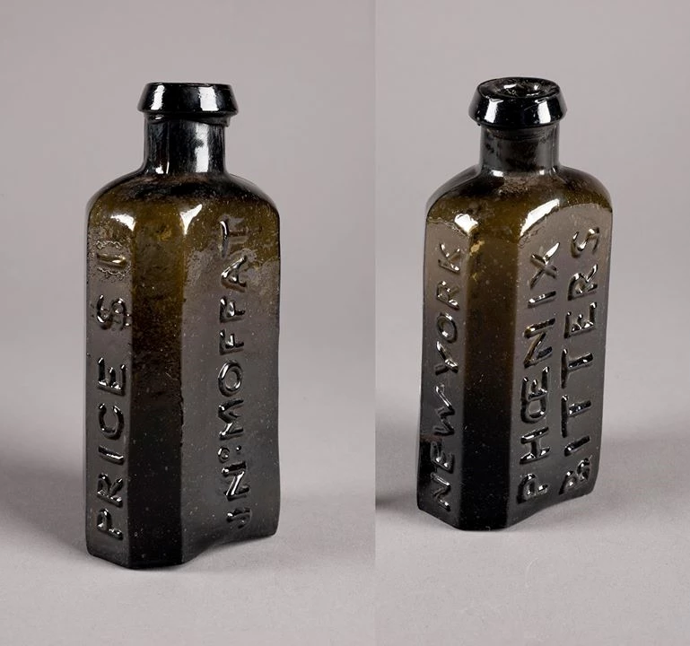 54385191_10156159858936367_4988200555449942016_o A front and back image of a dark glass medicine bottle.