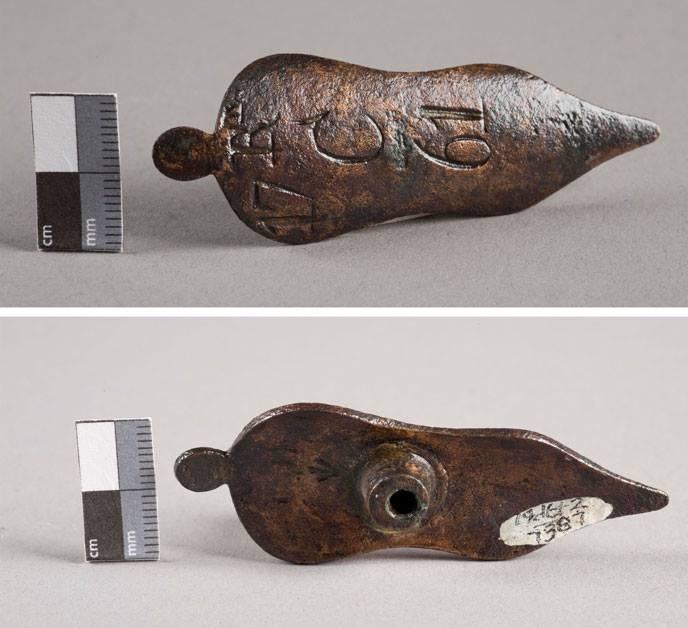 Front and back of a thin metal triangular object with pocks and engraving on the surface.