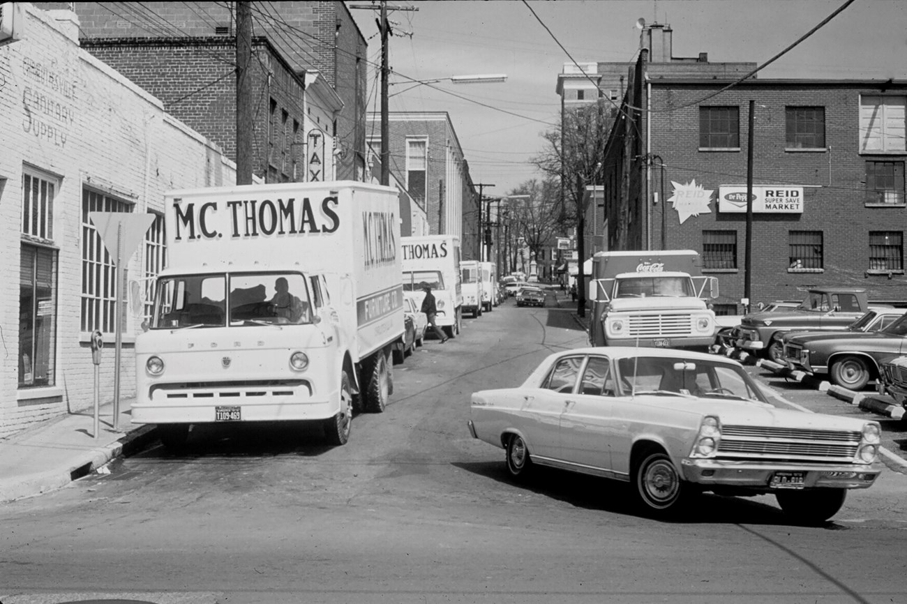 Historic street scene with cars and buildings