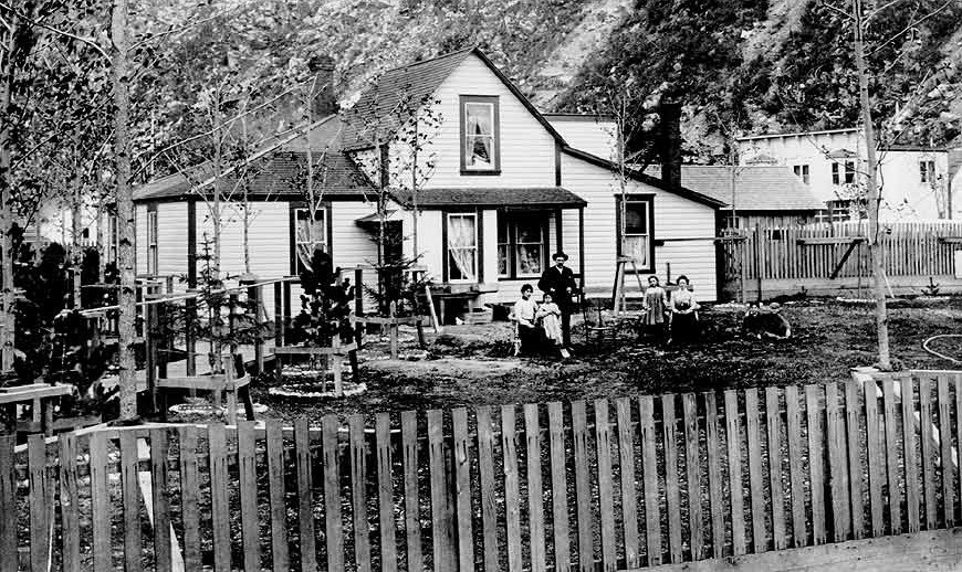 Family in front of a two-story house.