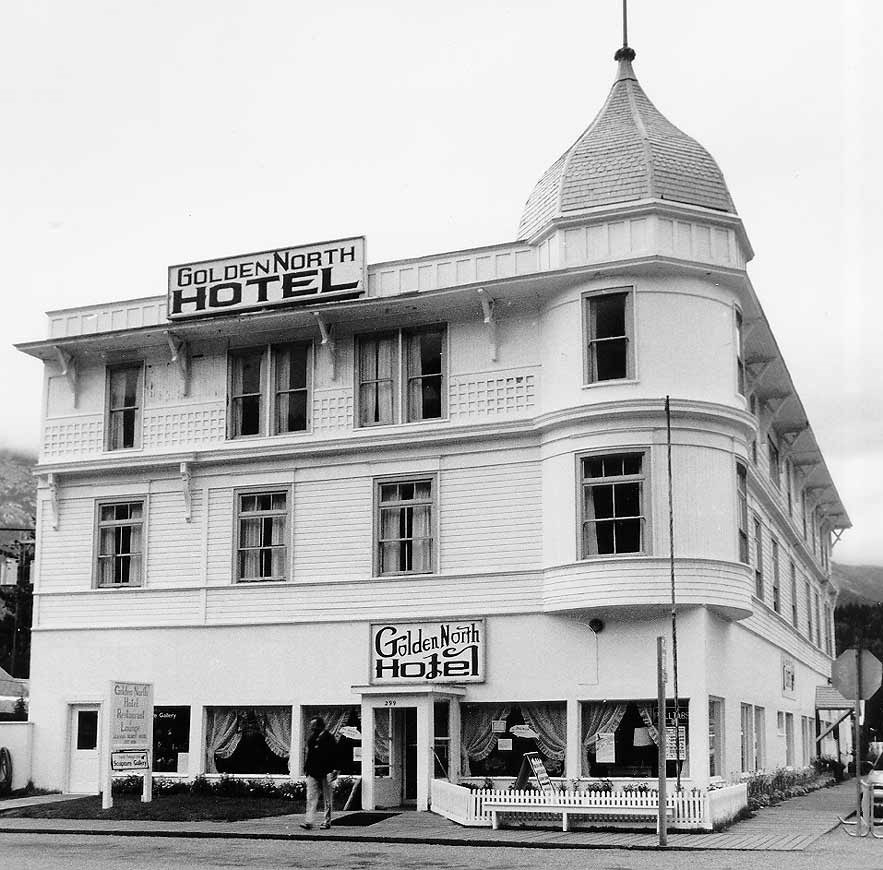 Three-story hotel with turreted roof.