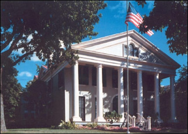 Exterior of white building with columns.