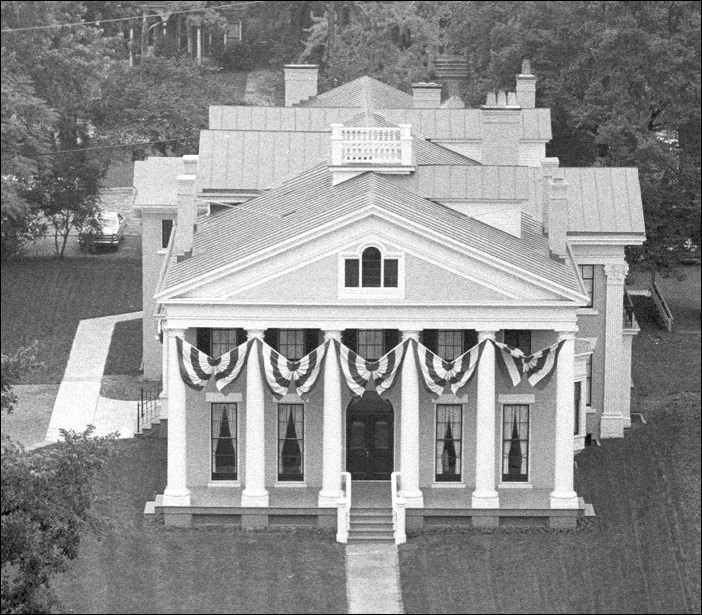 Aerial of large house with columns.