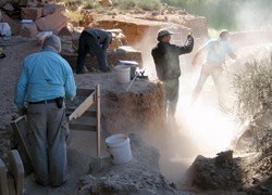 Dusty excavation along the Colorado River. Several people working along the excavation site