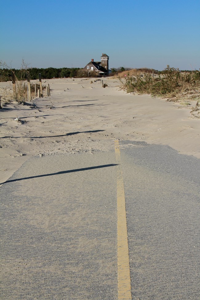 The multi-use path leading north towards the Lifesaving Station disappears under a wash of sand.