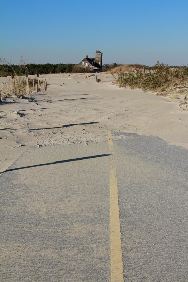 lt= The multi-use path leading north towards the Lifesaving Station disappears under a wash of sand.