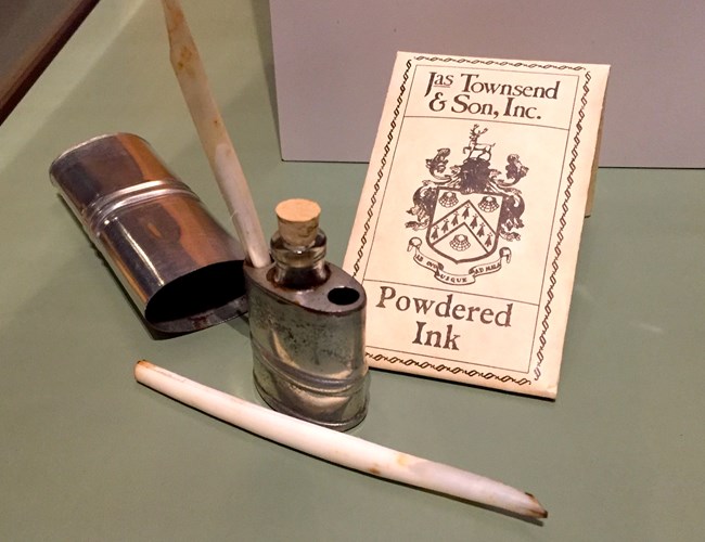glass bottle of ink and pen