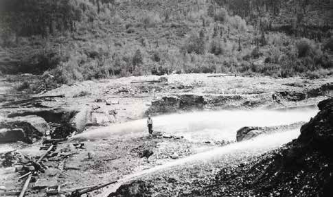 man standing in a valley near a hose spurting water man standing in a valley near a hose spurting water