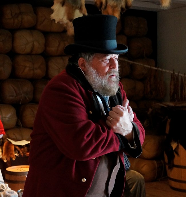 Photo of a man wearing 1840s style clothing and a beaver hat.