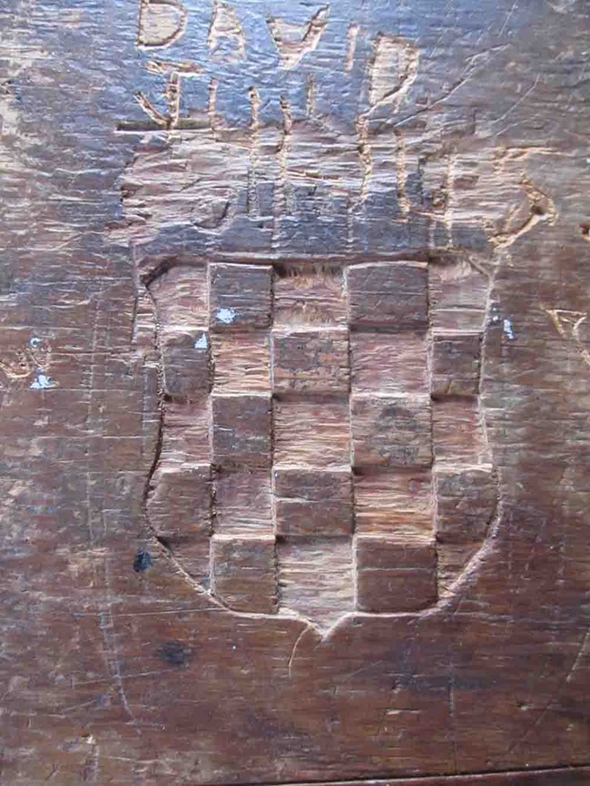 An old wooden table with the image of the Croatian flag carved in its top.