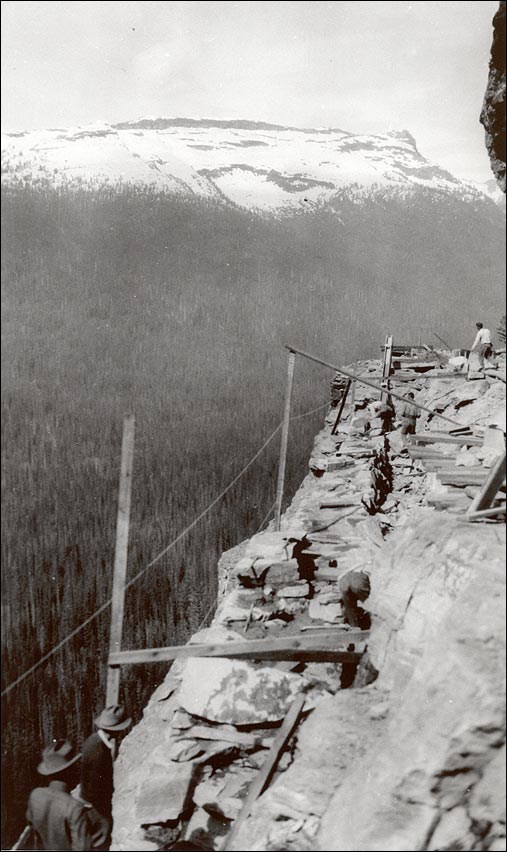 Men walking on the side of a steep mountain. 