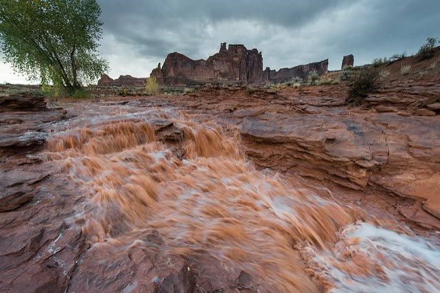 rushing water flooding over rocks with dark skies above
