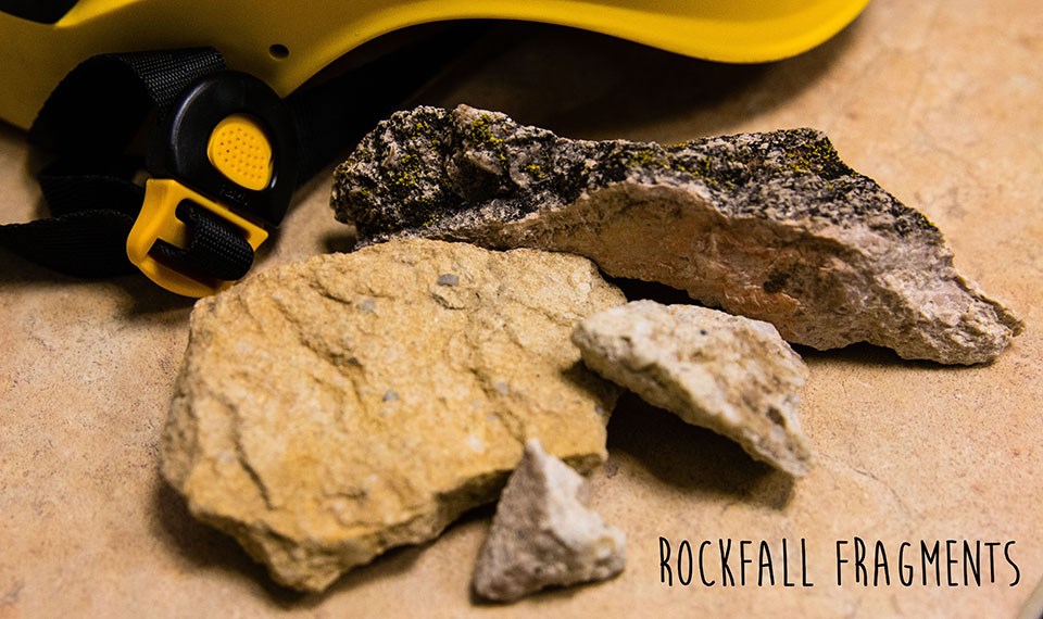 small rock fragments on desk with yellow helmet in background