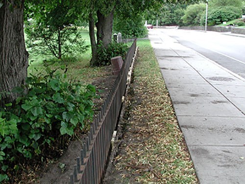 Metal fence along a sidewalk near a street