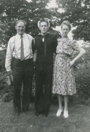 Mr. And Mrs. Bass with Charlie A man and women standing next to a young man in a navy uniform.