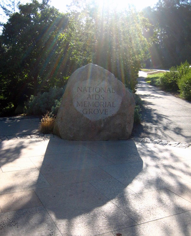 View of a large boulder engraved "National AIDS Memorial Grove"