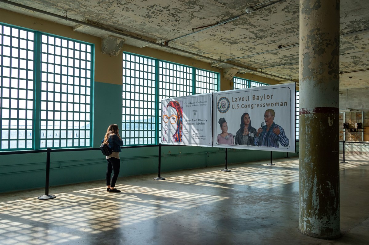 Person gazes at two future id banners in front of light filled warehouse window. Person gazes at two future id banners in front of light filled warehouse window.