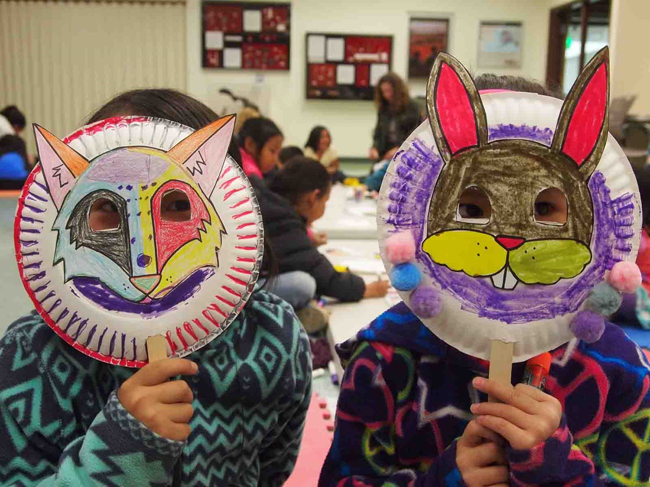 Children from a native village make animal masks.