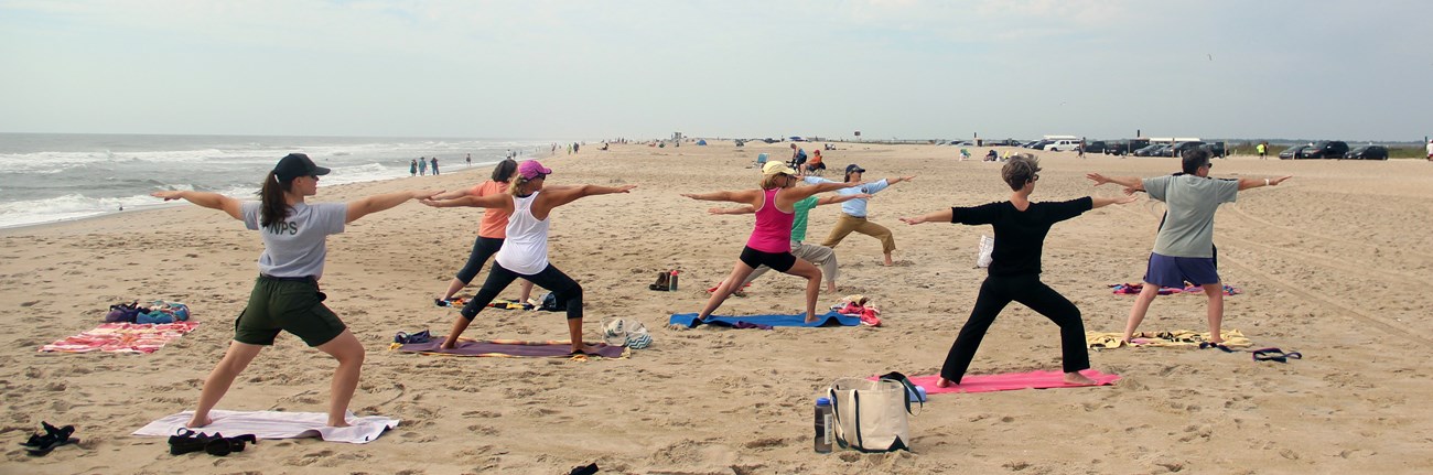 ASIS Yoga Group doing yoga on the beach with a ranger