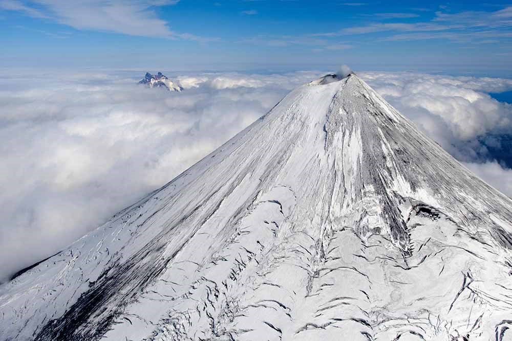 A view of a snow-covered volcano from the air.