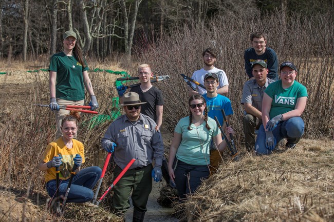 Volunteers and park rangers pose with branch clippers.