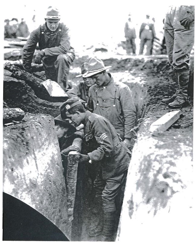 An instructor demonstrates proper trench reinforcement techniques for new recruits An instructor demonstrates proper trench reinforcement techniques for new recruits