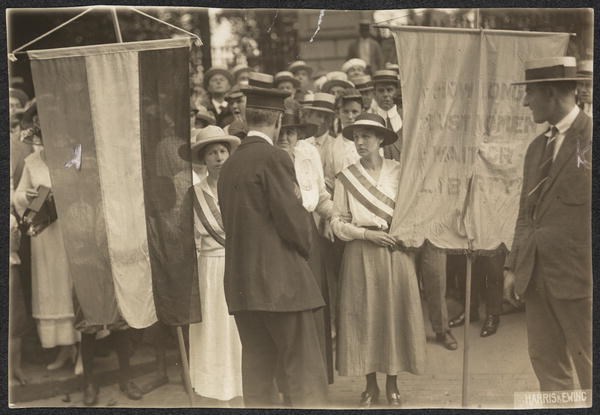 Two women being placed under arrest as they picket with banners before the White House East Gate.