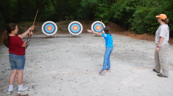 Archeologist instructing Girl Scouts how to throw Atlatl at Camp for All Seasons