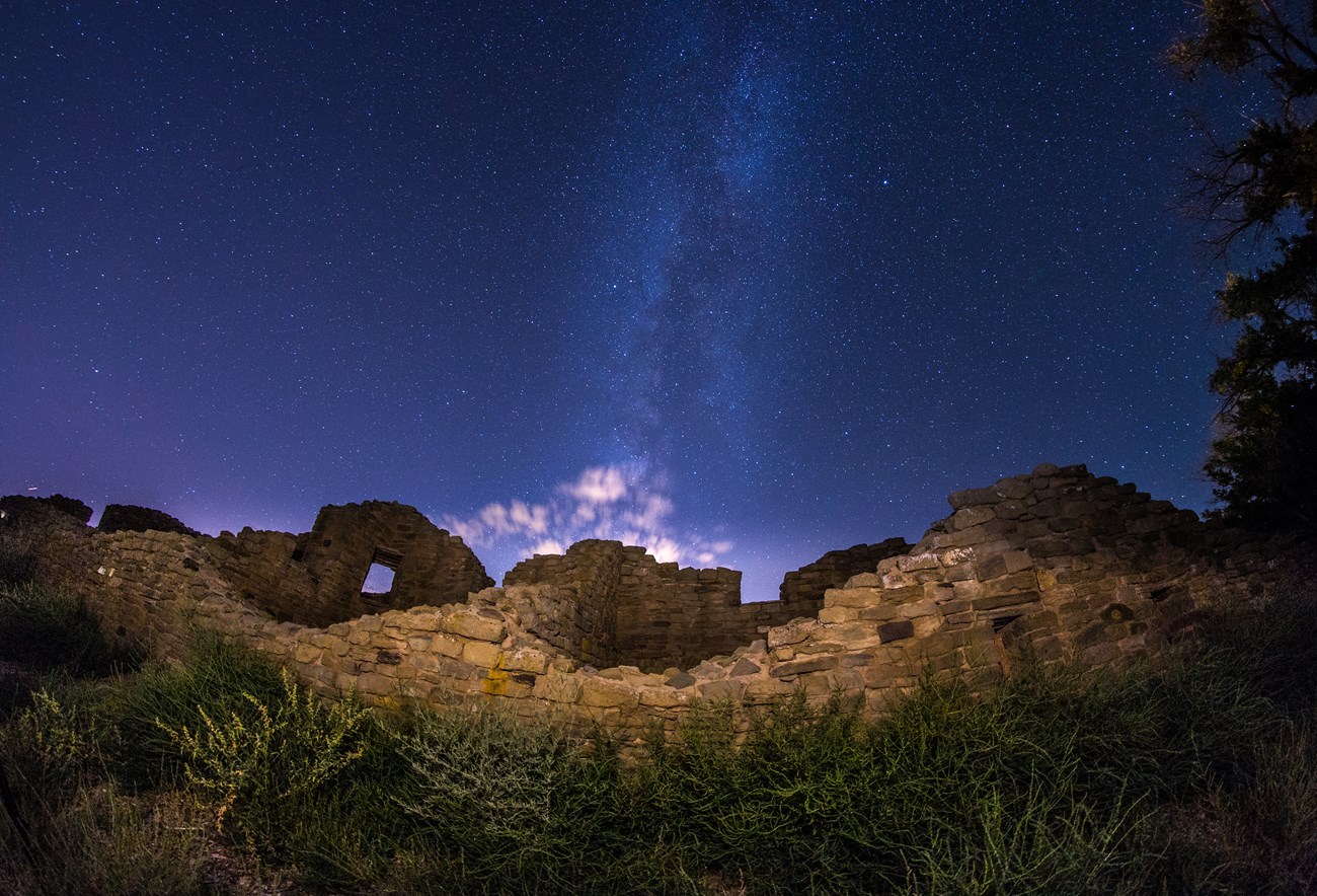 Puebloan ruins frame this view of the starry night sky at Aztec Ruins National Monument, New Mexico.