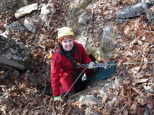 caver rappelling into a cave opening