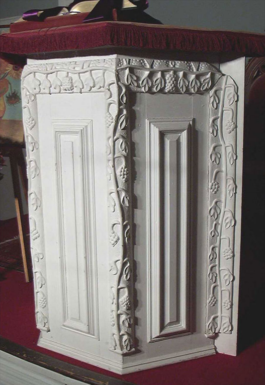 A carved white podium