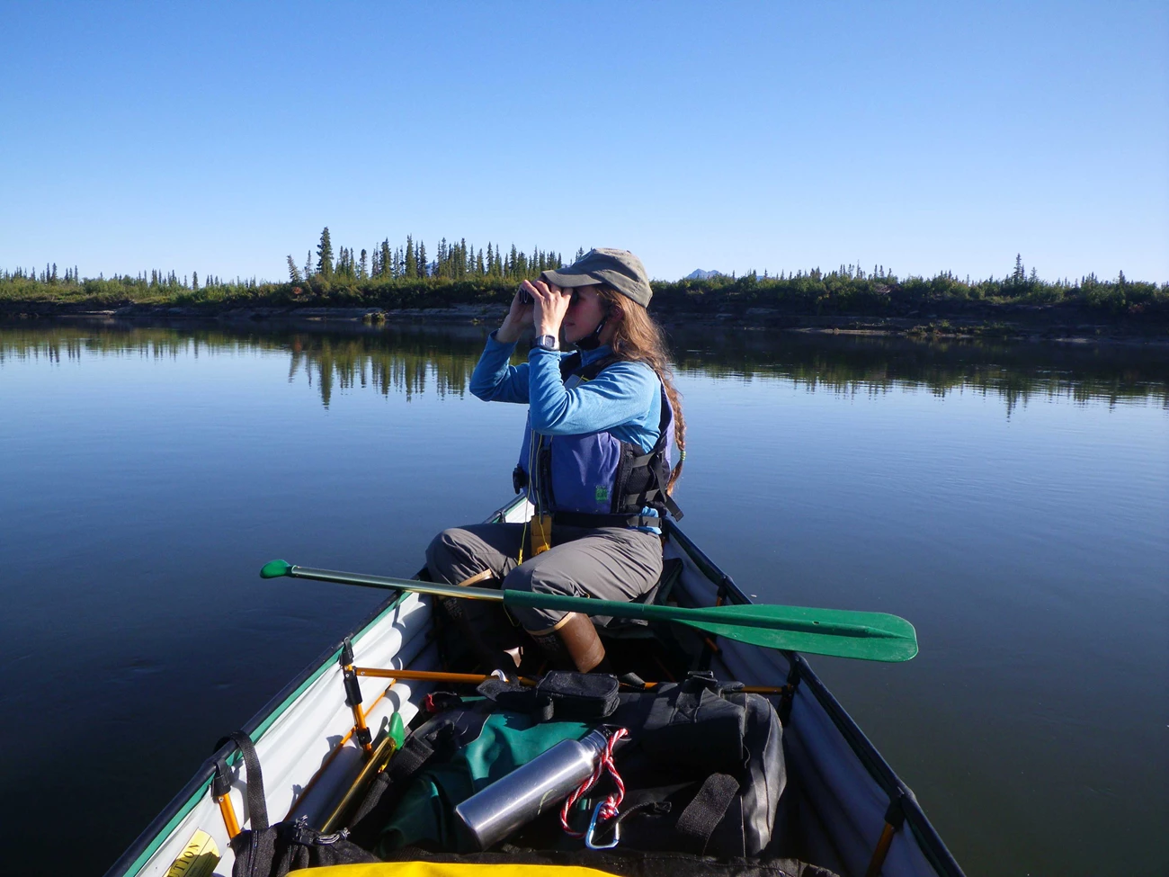Boater in a canoe using binoculars Boater in a canoe using binoculars