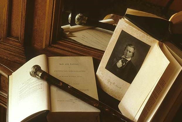 Man and Nature with walking stick. Open books on a table with a walking stick.