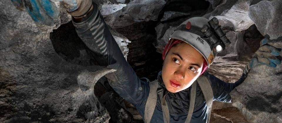 CARL Intern intern wearing helmet and gloves in a cave