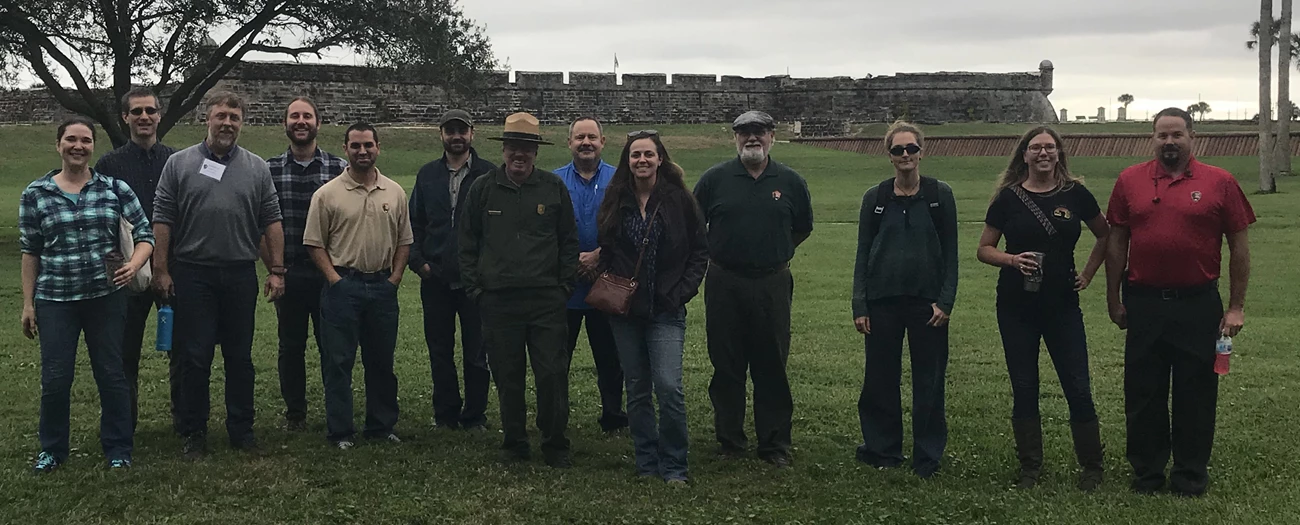 Steering committee meeting at CASA Group of people standing in front of an old fort