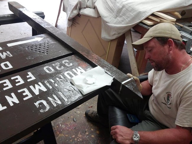 Billy painting a sign A man painting a sign