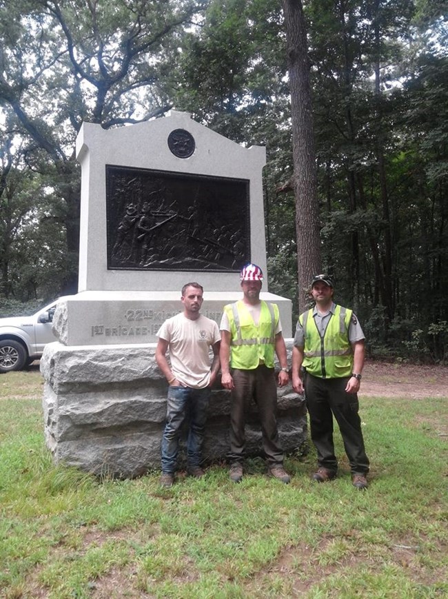 Preservationist Kiel and his crew Billy and Pat Three men standing next to a a monument.