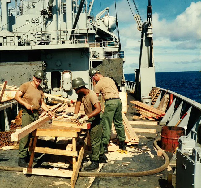 Daniel Hodgson on a ship Daniel Hodgson does carpentry on a ship with two other Seabees.