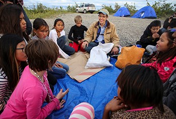 A group of campers sit around an instructor