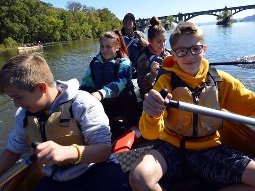Canoemobile event at Columbia Crossing Young student paddle a canoe.