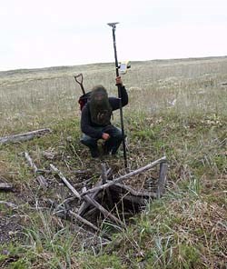 University of Alaska, Fairbanks graduate student Cody Strathe examines a historic period cold cellar. (NPS photo)