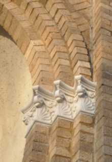 Cast stone on Central High School Three brown brick and white stone architectural pillars.