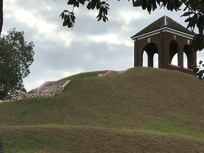 Cemetery pavilion Brick stairs on a green hill lead up to a brick pavilion