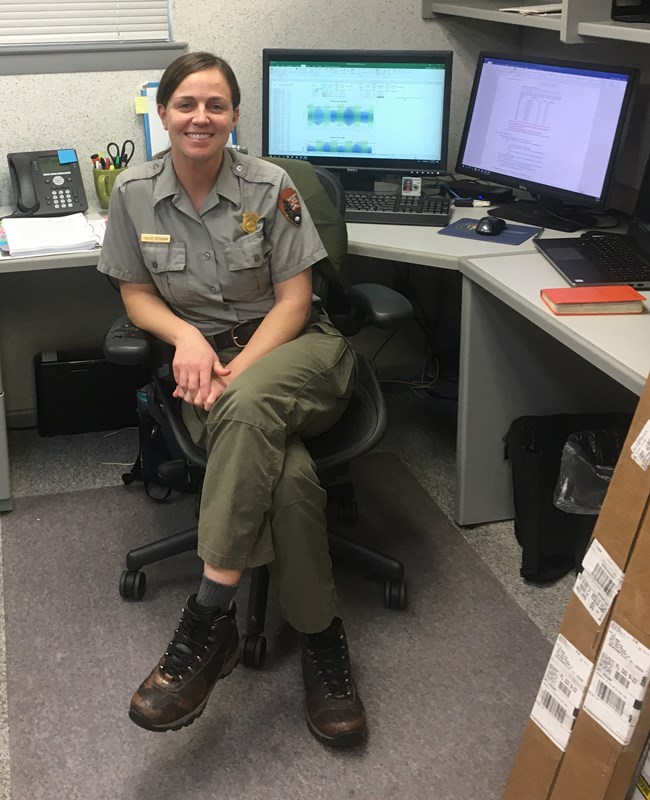 Chelsey Stephenson woman sitting in chair in front of desk with computer monitors