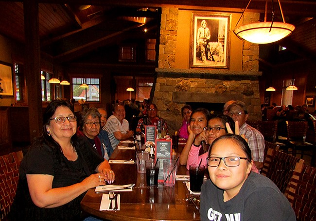 Elders and students sit together around a table. Elders and students sit together around a table.