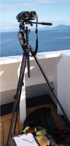 GLBA Binoculars1 a pair of rangefinder binoculars on a tripod overlook the ocean from a boat in glacier bay national park