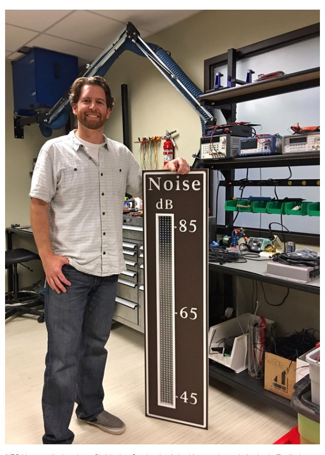 NPS bio-acoustical engineer Christopher Garsha stands beside a newly created noise traffic display sign.