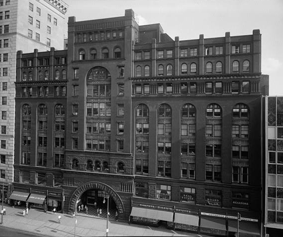 Black and white street view image of the brick Cleveland Arcade building.