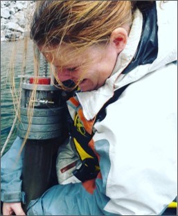 Danielle Haskett at work Close up of researcher pulling up sediment coring equipment