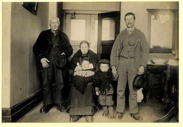 elderly man standing next to a younger man and woman, as well as two small children